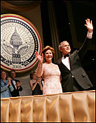 President George W. Bush and Laura Bush greet the audience during the Texas State Society's Black Tie and Boots Inaugural Ball in Washington, D.C., Jan. 19, 2005. White House photo by Eric Draper.